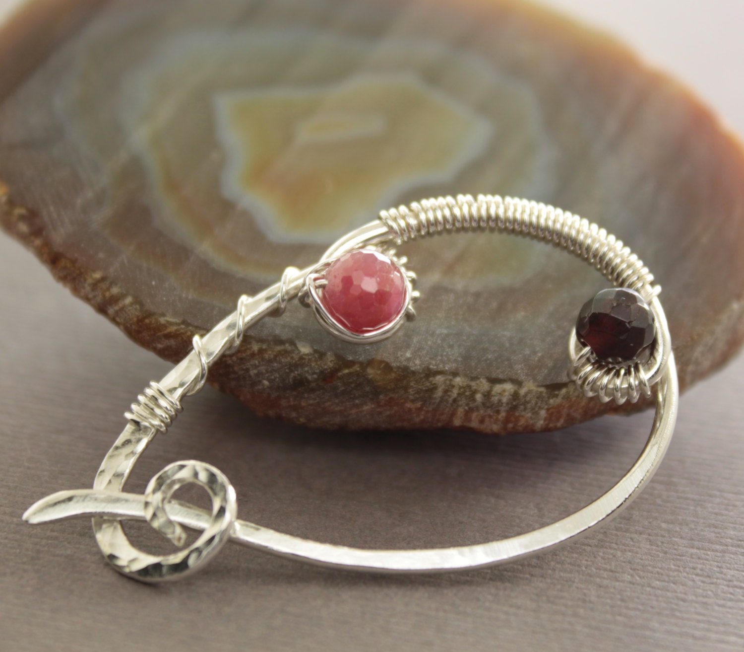 Sterling silver shawl pin or scarf pin in a swirly drop design with ruby and garnet stones