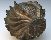 Carved porcelain pod in bronze with gold luster