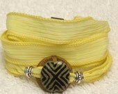 Silk Ribbon Whirly Wrap Bracelet in Buttercup Yellow with a ceramic tribal accent piece Karen Blixen Museum