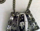 Upcycled chunky vintage rhinestone buckle as pendant with handhewn clay center and black netting