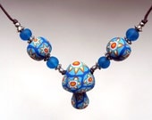 Millefiori mushroom pendant necklace with tribal designs, inspired by Native American beadwork, with blue glass beads on adjustable cord
