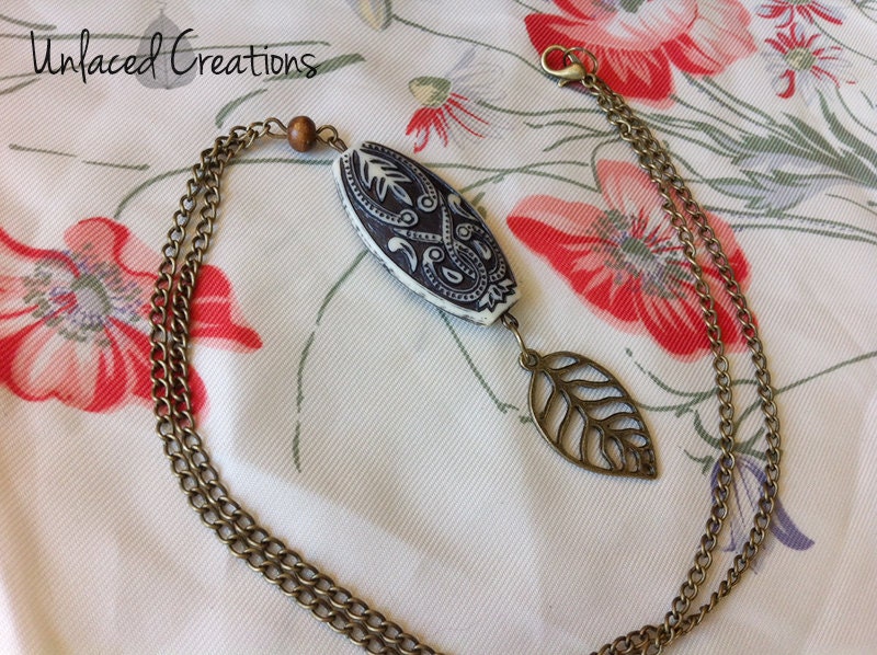 cate. a brass leaf and etched bead bohemian necklace.