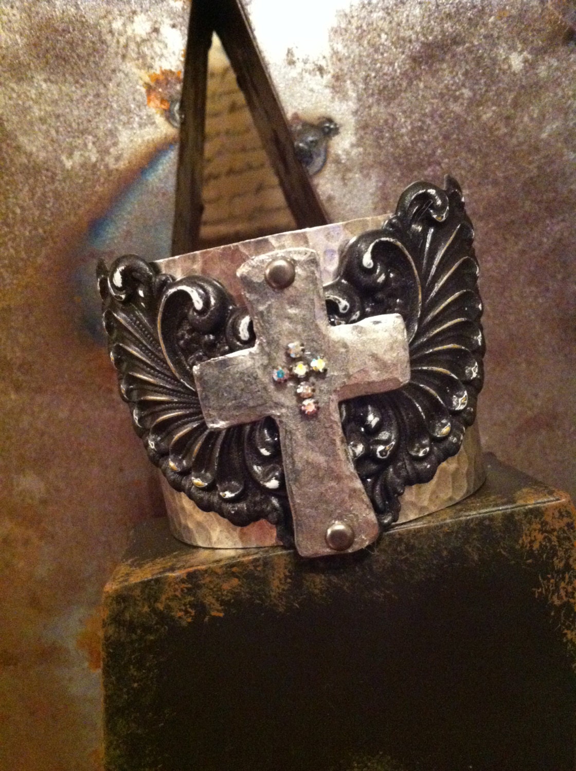 Metal cuff bracelet with hammered metal cross and wings