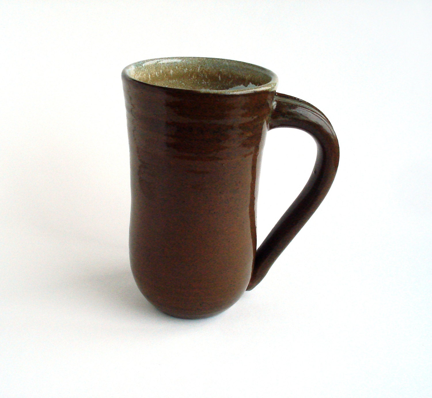 Tall stoneware mug: brown pottery with white interior