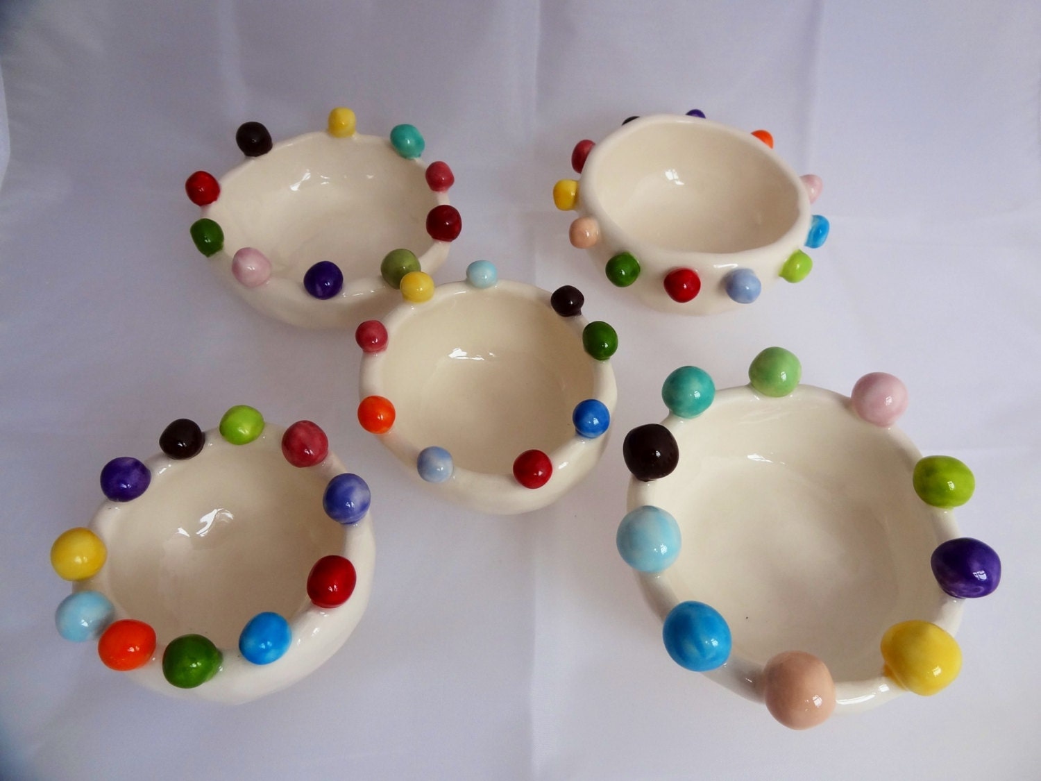 Small handmade ceramic bowl, with multicoloured bobbles around the top.