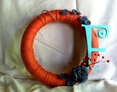 Yarn wrapped wreath with F initial and handmade flowers.