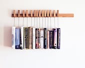 Custom made wooden book rack / bookshelf in Oak. The pins are also bookmarks.
