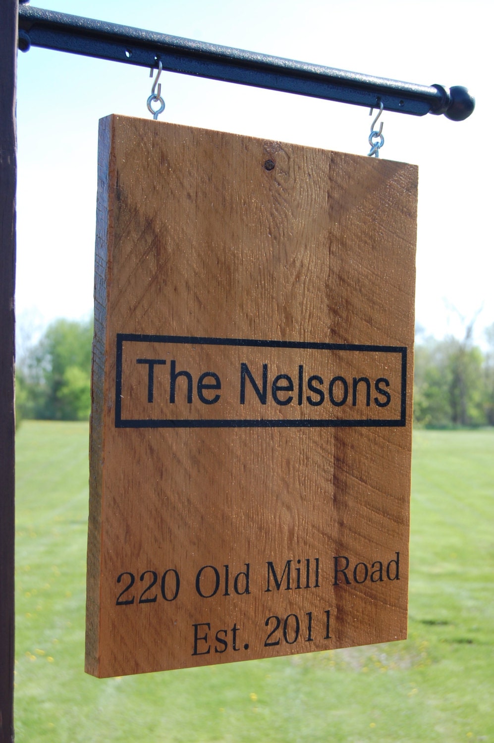 Personalized sign hanging from metal post. Painted on barn wood.