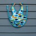 Adjustable waterproof bib, whale print, with snaps and pocket
