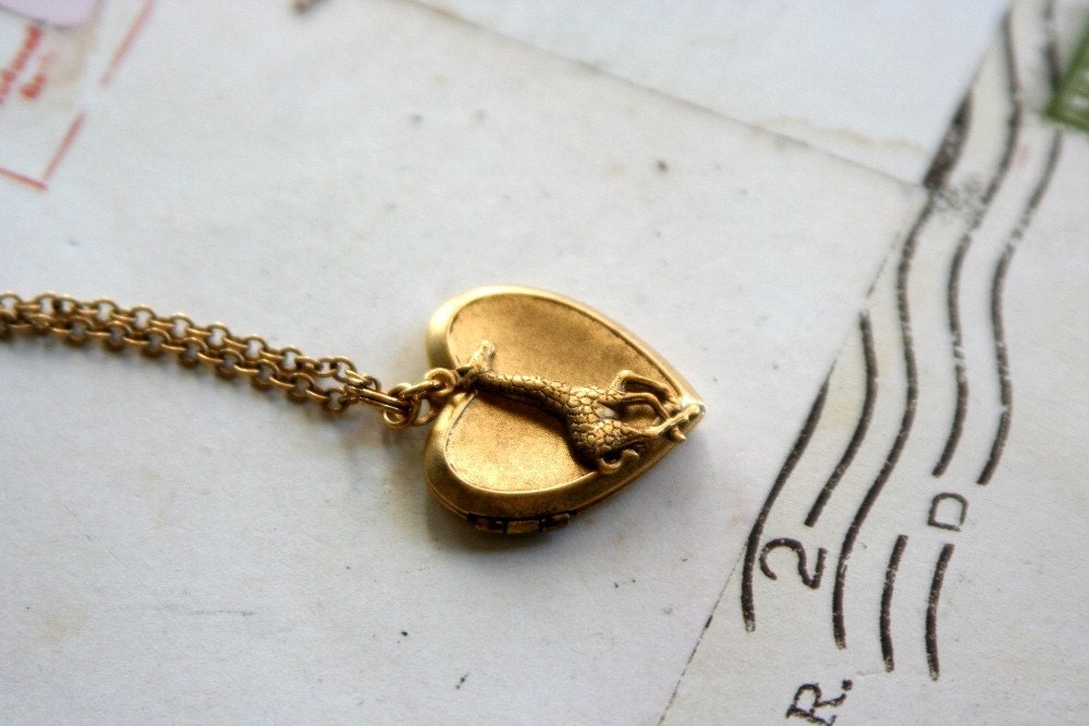 loves giraffes. locket necklace. gold ox color