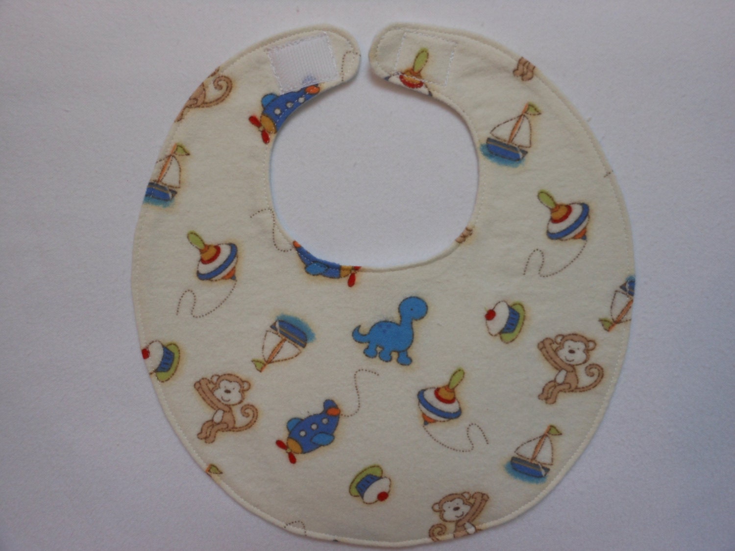 Baby Bibs, four soft layers, reversible, cream with blue dinos, and brown monkeys