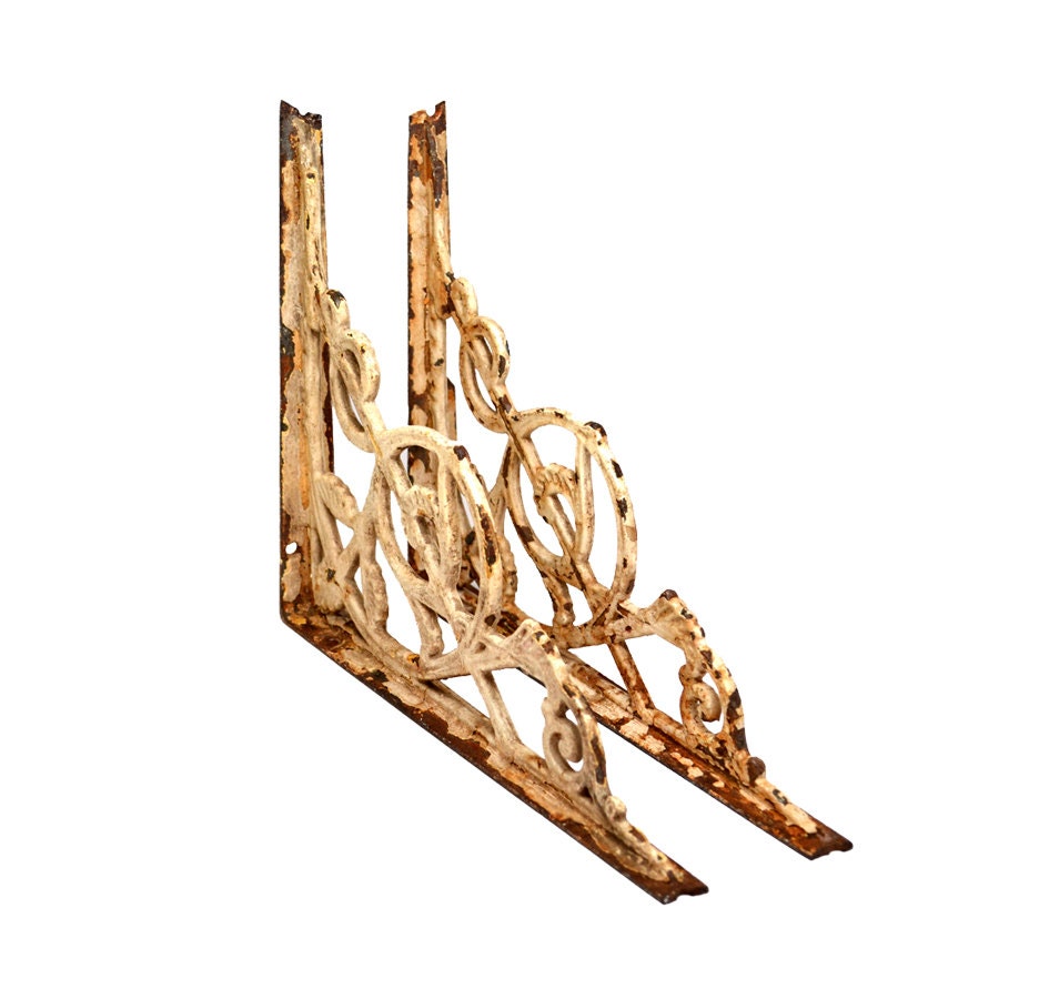 architectural salvage ornate metal brackets with white chippy paint and rust  offered by Elizabeth Rosen