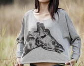 Giraffe in grey sweatshirt .
