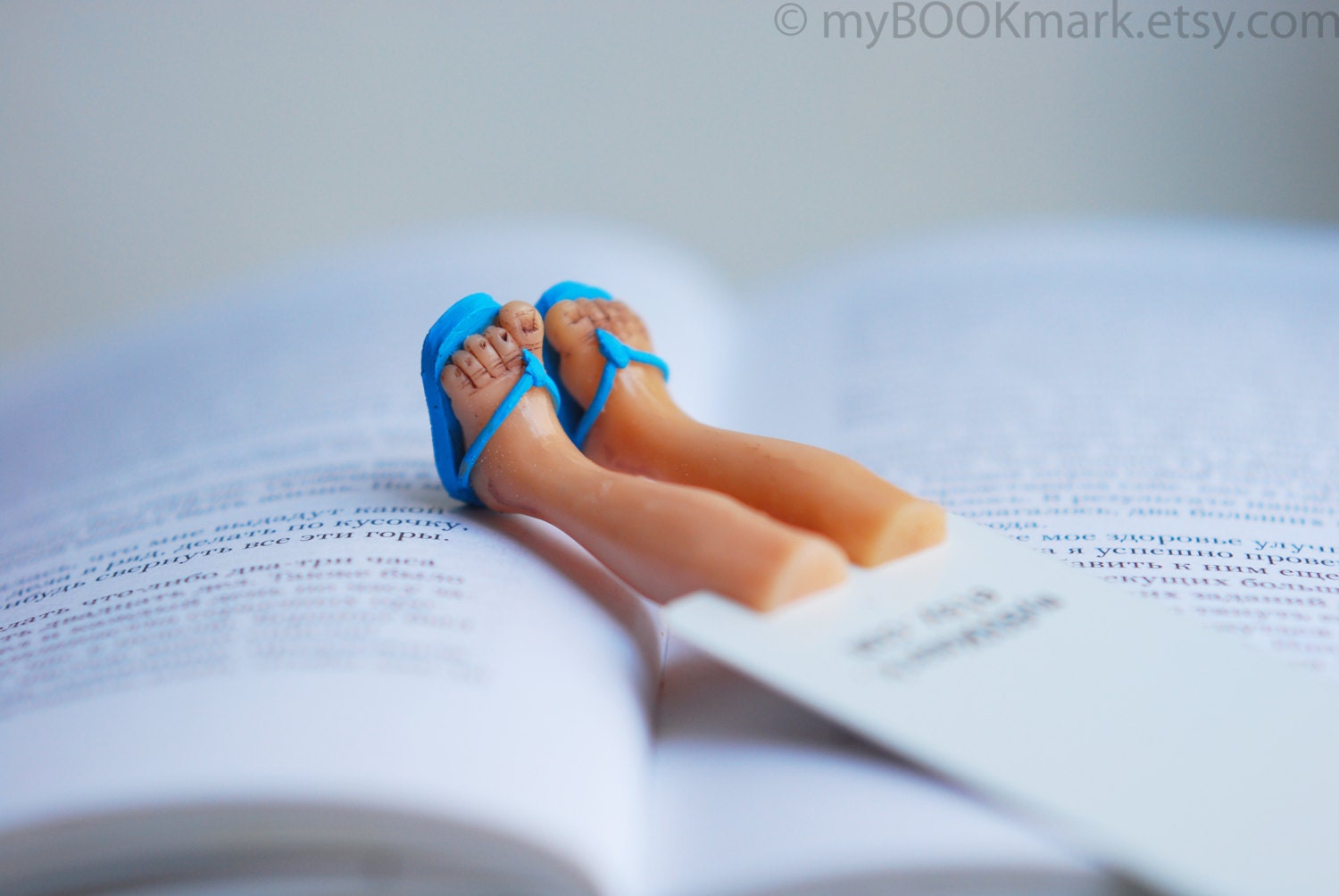 Summer bookmark. Legs in blue summer flip-flops. Aqua blue for him. Nautical for vacation by the sea . Beach reading