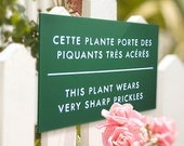 Funny sign for Flower gardens. Rose bush, Cactus Signage. French Humor. This Plant Wears Prickles