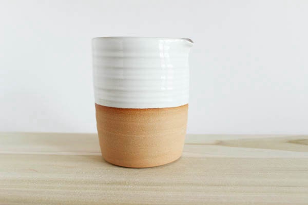 White ceramic pitcher, white creamer, on medium brown pottery, julia paul pottery