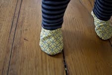 MTNkids Mocs, a cloth baby shoe with faux shearling inside. Shown in yellow and grey mod pattern: Newborn-2T available