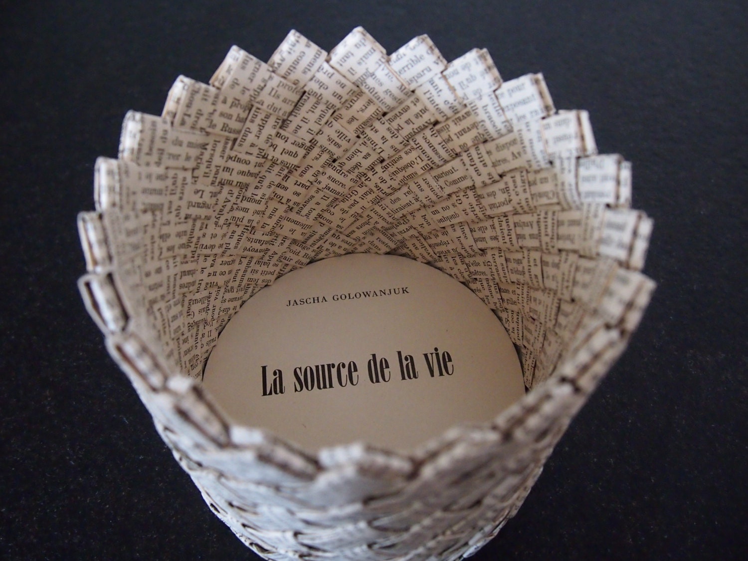 Paper storage basket woven from vintage book
