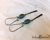 moira. a pair of simple brass drop earrings with etched turquoise beads.