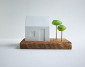Miniature glowing house with little green trees