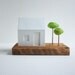 Miniature glowing house with little green trees