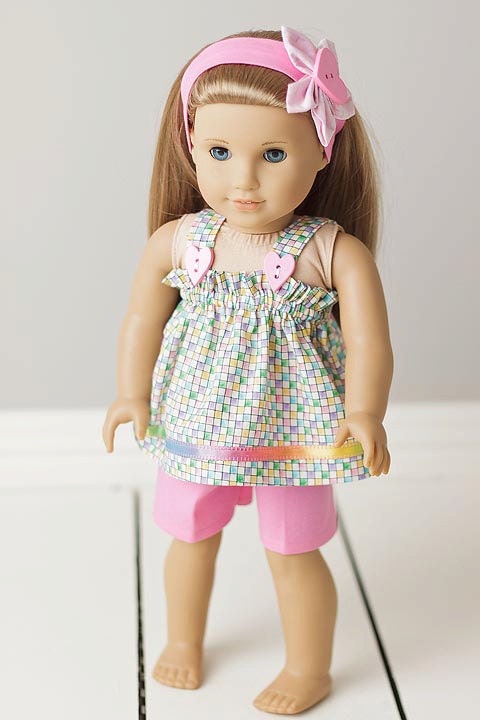 Summer time outfit with pink shorts and a pastel multi-colored checked smocked top, with a headband