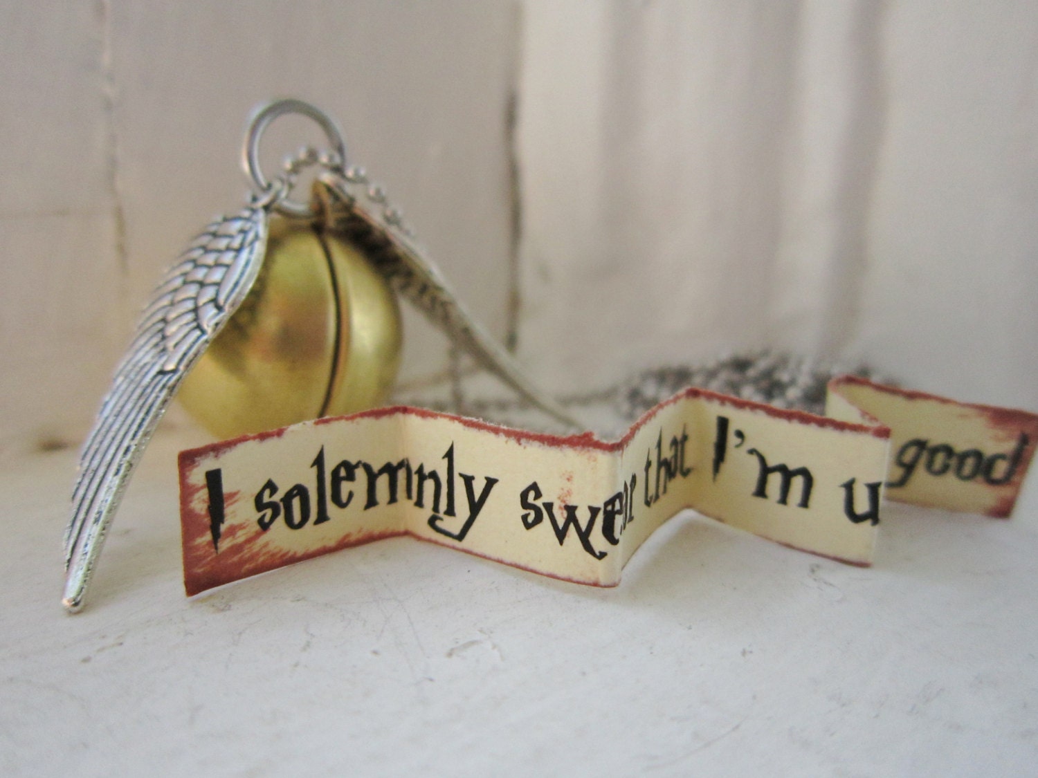 Golden Snitch brass locket necklace with personalized message on a stainless steel chain