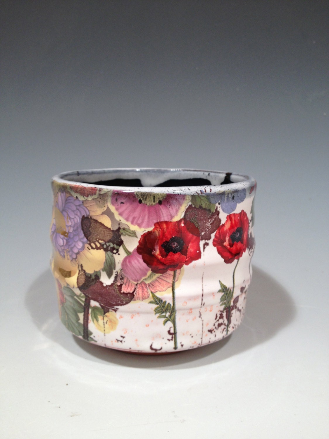 Large cup with black and white glaze, poppies, and patterns