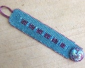 Bead woven cuff bracelet. Iridescent aqua, turquoise and fuchsia beads. 7 1/4 inch length. Crystal glass button