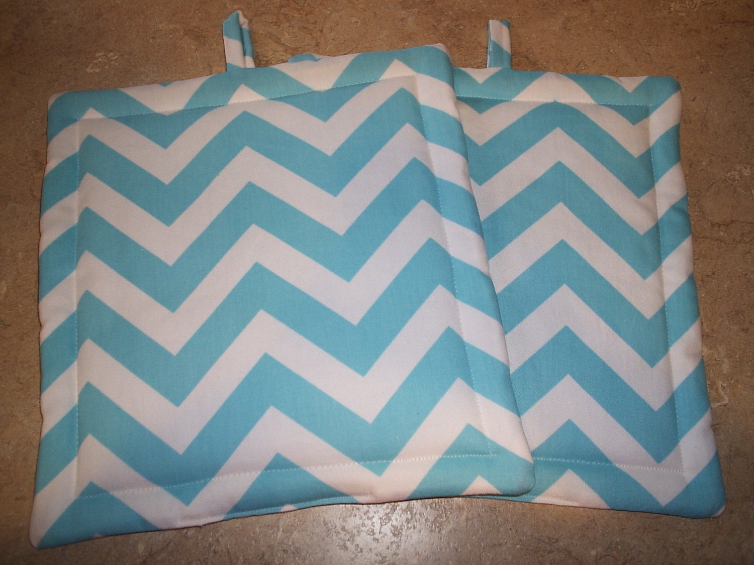 Set of 2 Potholders in Aqua and White Chevron fabric.