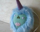 Plush monster ornament, blue, green, and purple