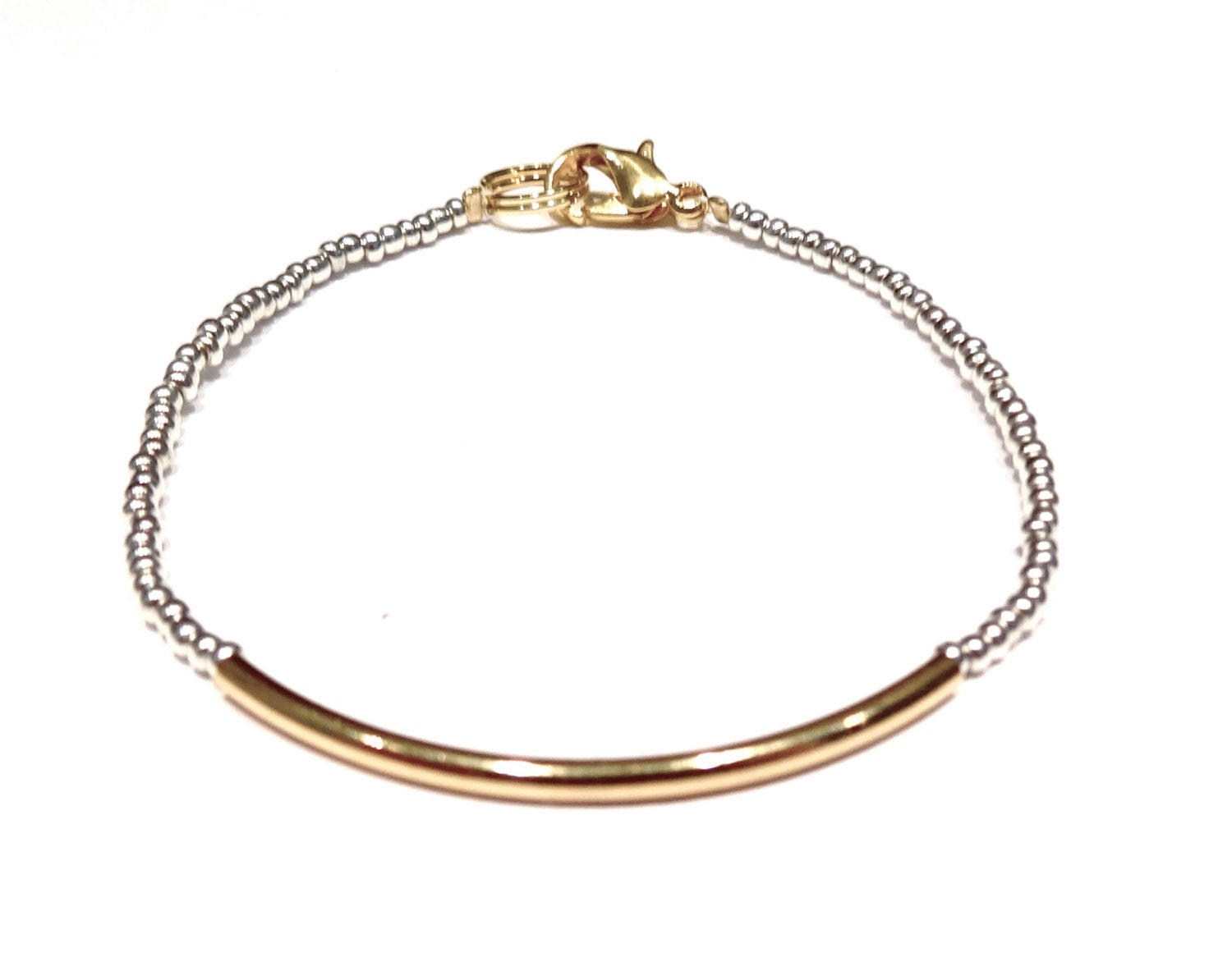 metallic heartlines w gold curved bar // dainty bracelet with cylindrical curved gold plated bar and shiny silver seed beads