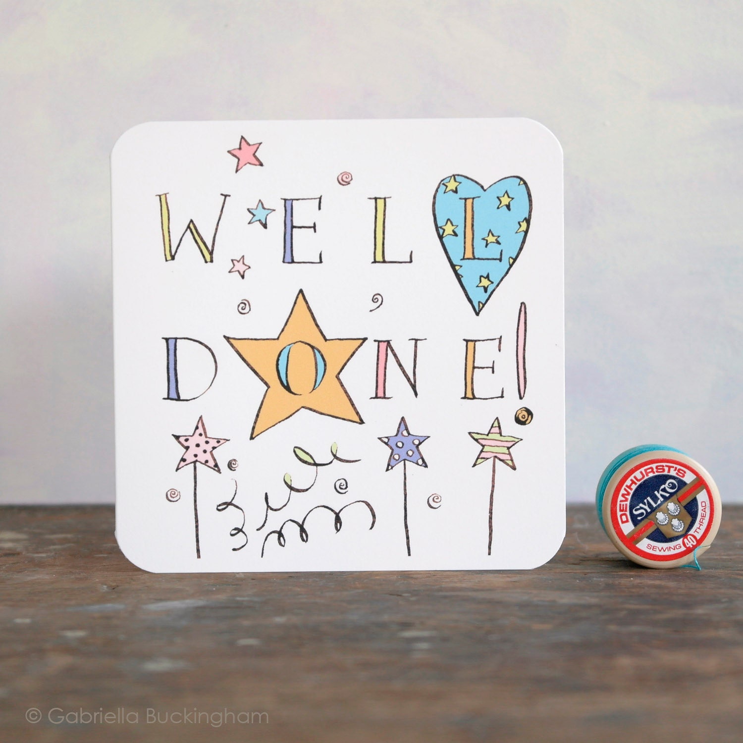 A blank Congratulations card with "Well Done" on the front in a colourful ink drawing by Gabriella Buckingham