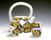 Ceramic and porcelain pottery tea set with four matching tea bowls.