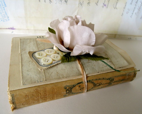Vintage ephemera collection with french poetry book, handwritten letter, old mother of pearl buttons and music.