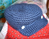 Newborn size Newsboys hat in navy with button details.