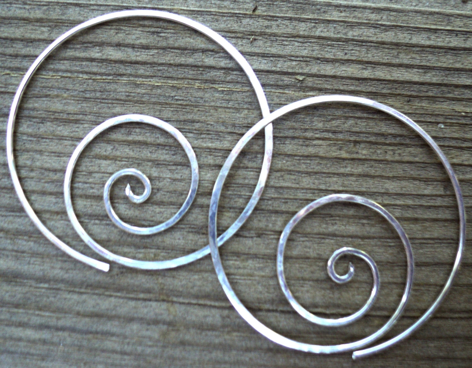 Sterling silver hand-hammered spiral hoop earrings. Medium sized one-piece women's earrings.