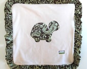Organic fleece baby blanket with hand ruffled satin edge and turtle appliqué.
