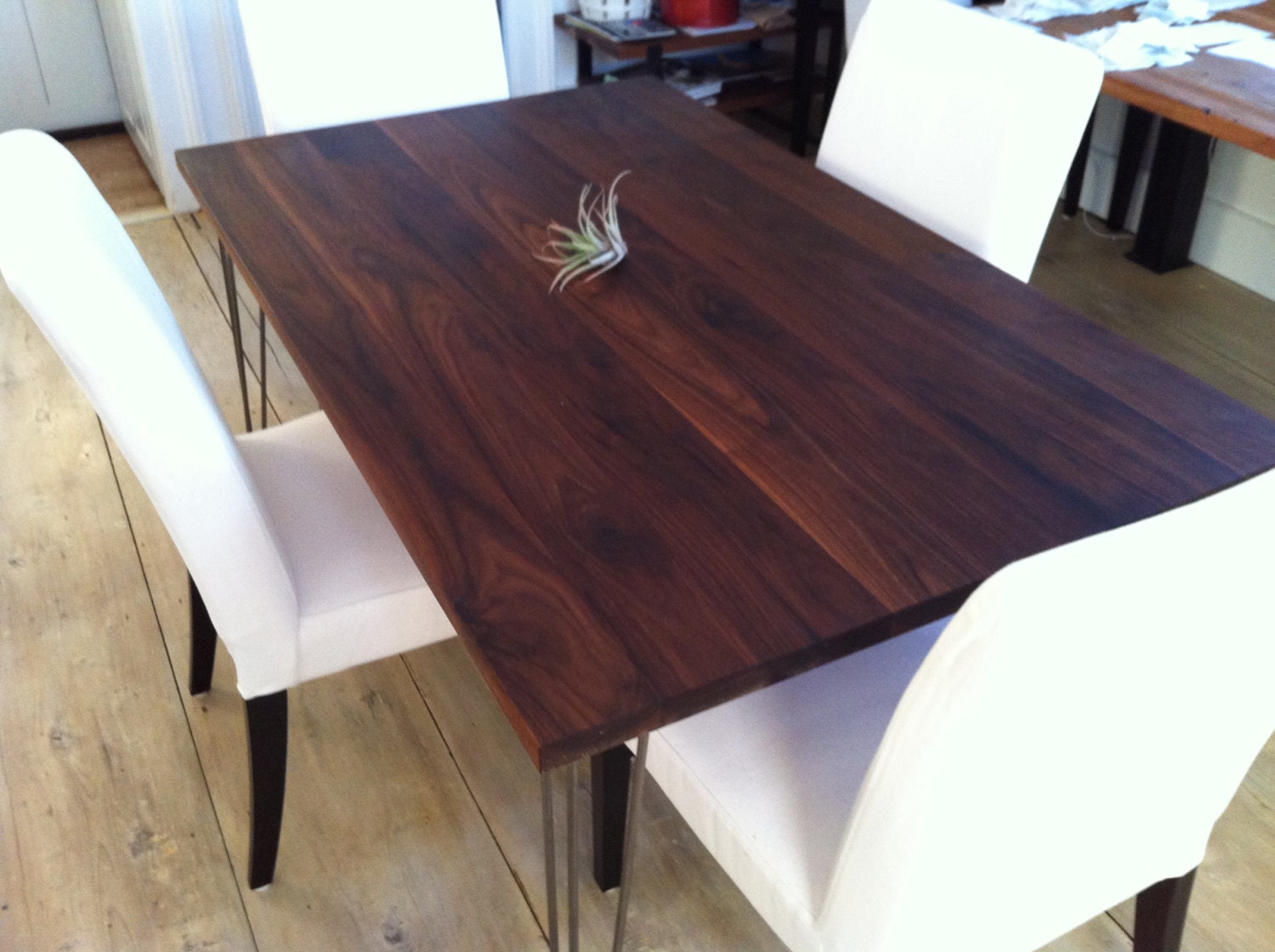 Walnut dining table, modern industrial style featuring hairpin legs.