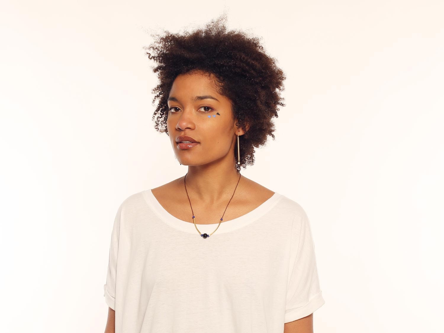 Necklace runs, tubes in brass gilded in the blue fine gold, black pearl in onyx and pearls of loose stones electric blue