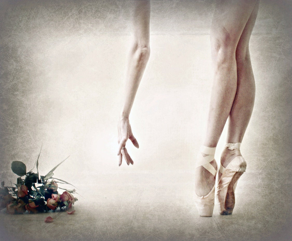 En Pointe.  Image of a dancer's legs and her hand reaching for a bouquet of roses at her feet.