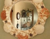 131/2 x 131/2 round beautiful handmade mirror. Embellished with a variety of shells, starfish, large scallop shells.