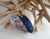A handmade patchwork shaped heart ornament in blue and cream