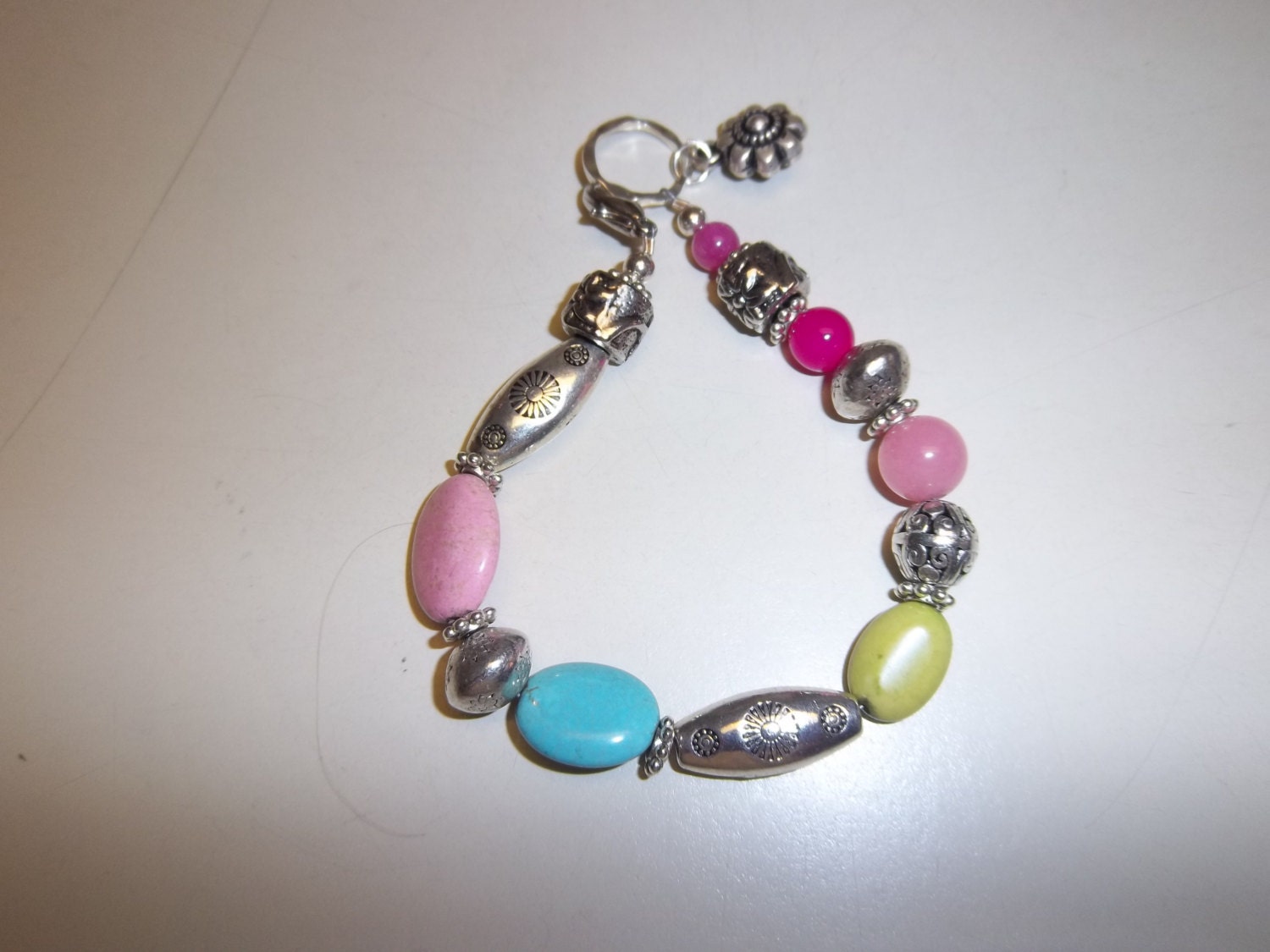 Handmade 8 1/2" silver bracelet with pink, turquoise, green  pink stones with silver misc. decorative beads, silver flower charm and toggle