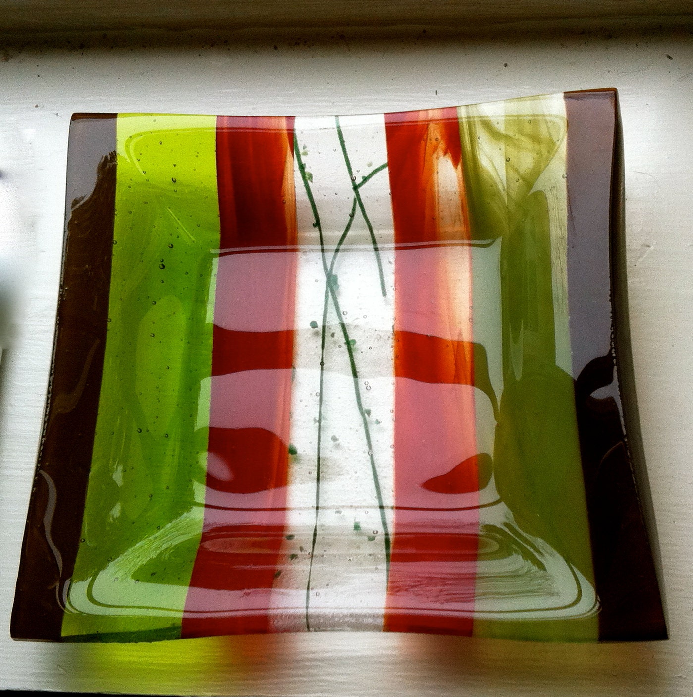 Small glass dish that can be used to hold coins or trinkets or on a table for small items.