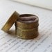 Antique brass McGill's Fasteners tin custom ring box with truffle-colored velvet lining.