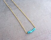 Dainty gold necklace with blue turquoise faceted gemstone beads.