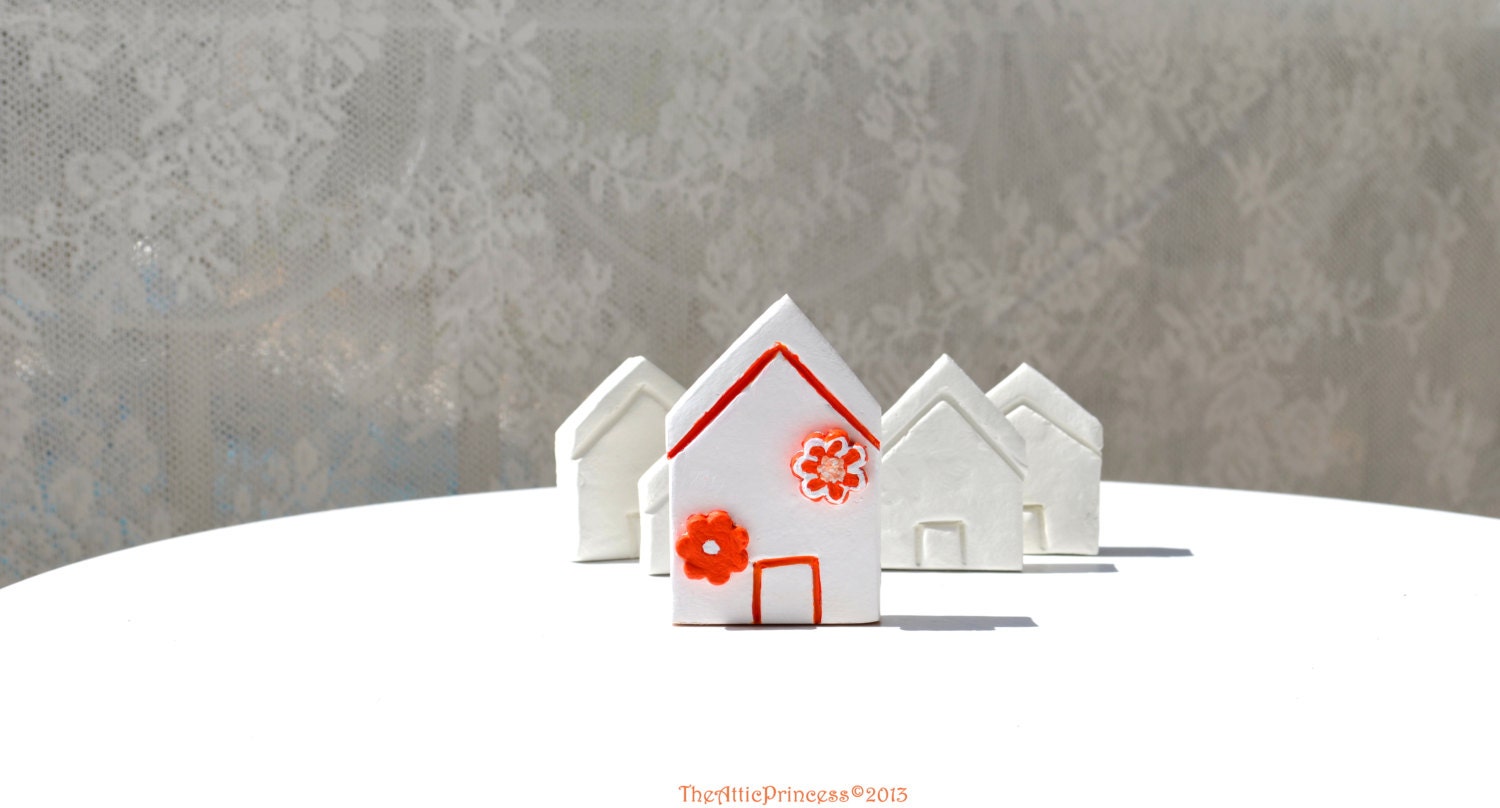 Miniature white clay house with orange flowers, spring home decoration