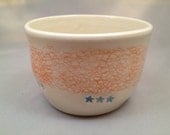Creamy white bowl with orange texture and blue stars