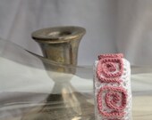 Crocheted white bracelet with pink adornment